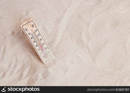 summer composition with sand thermometer