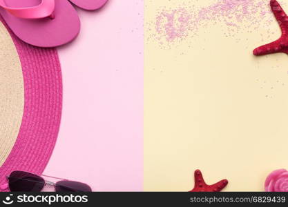 Summer concept. Beach accessories, hat, sunglasses, flip flops on pink and yellow background. Flat lay. Minimal style. Copy space. Top view.