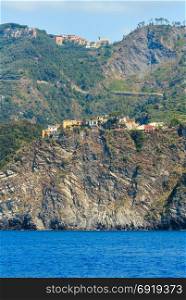 Summer Corniglia view from excursion ship. One of five famous villages of Cinque Terre National Park in Liguria, Italy, suspended between Ligurian sea and land on sheer cliffs.