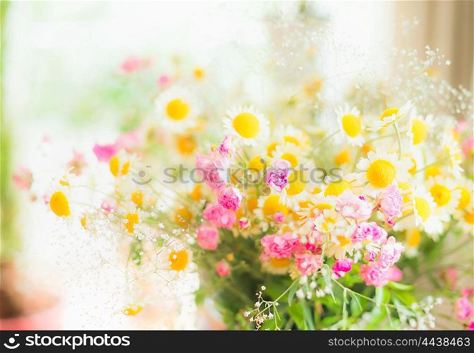 Summer daisies bunch with little pink roses at window background