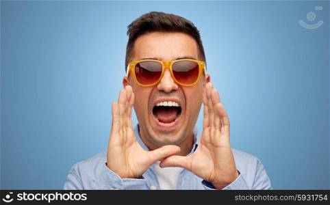 summer, emotions, communication and people concept - face of angry middle aged latin man in shirt and sunglasses shouting over blue background