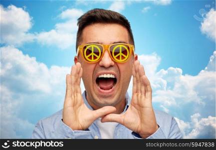 summer, emotions, communication and people concept - face of angry middle aged man in sunglasses with green peace symbol over blue sky and clouds background