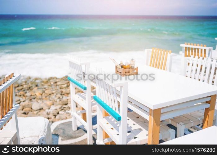 Summer empty open air cafe near sea at greek island. Summer empty open air luxury restaraunt at exotic hotel