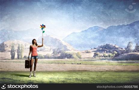 Summer energy. Happy young woman with windmill in hand