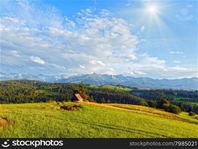 Summer evening mountain village outskirts and Tatra range behind(Gliczarow Gorny, Poland)