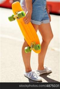 summer, extreme sport and people concept - teenage girl with short modern cruiser skateboard on city street