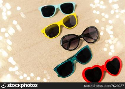 summer, eyewear and accessory concept - different sunglasses on beach sand. different sunglasses on beach sand