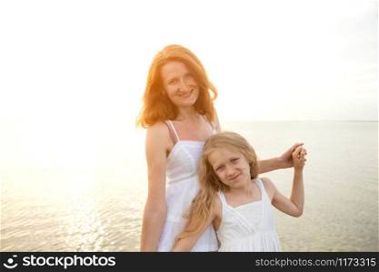 summer family lifestyle. mother with daughter at the evening sea