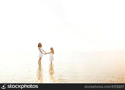 summer family lifestyle. mother with daughter at the evening sea