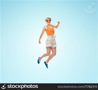 summer, fashion and people concept - happy teenage girl in sunglasses jumping over blue background. happy teenage girl in sunglasses jumping