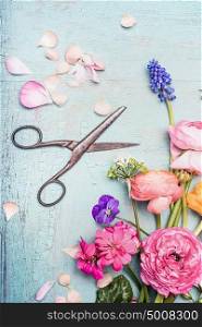 Summer flowers bunch making with various colorful flowers from garden and shears on blue vintage shabby chic background, top view, copy space