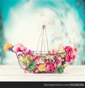 Summer flowers in basket on table at turquoise blue sky background, fron view, gardening concept