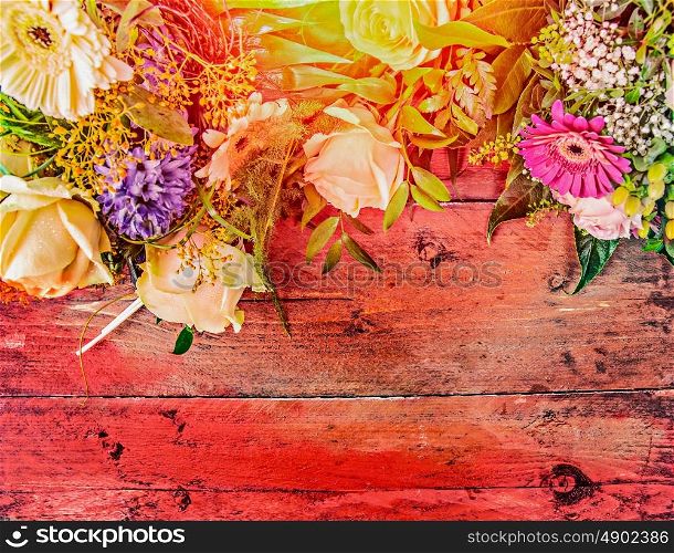 Summer flowers on red wooden background, top view, place for text, toned