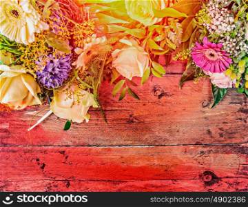 Summer flowers on red wooden background, top view, place for text, toned