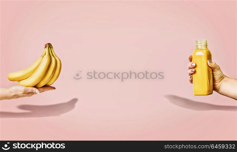Summer food and beverages background with bananas and yellow drink bottle in female hand at pastel pink background, front view, banner or template.