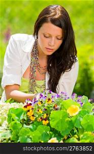 Summer garden beautiful young woman care colorful flowers