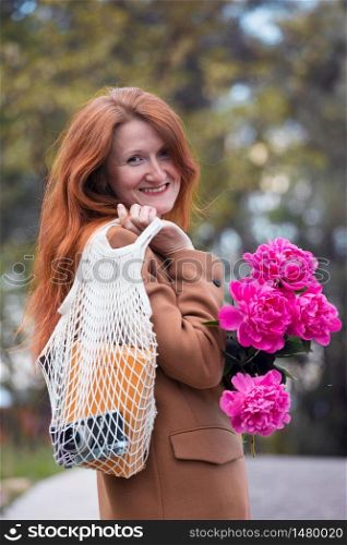 summer - happy beautiful girl with bouquet of peonies