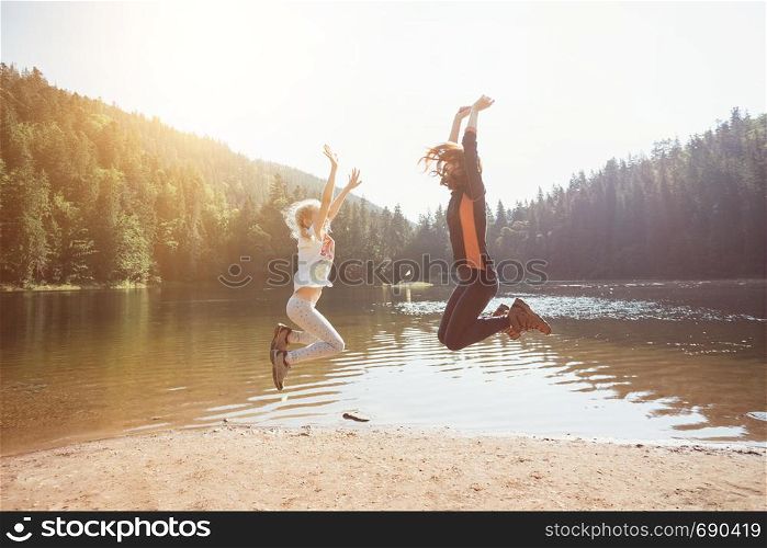 Summer - happy family on a hike. Fun happy family jumping on the shore of a mountain lake synevyr.