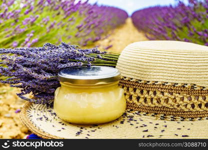Summer hat and glass with honey against fresh lavender field background. Attraction trip for french vacation in Provence.. Summer hat and jar with honey at lavender field. Holidays in France.