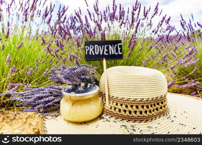 Summer hat, jar with honey and board with sign Provence against fresh lavender field. Attraction trip for french vacation.. Summer hat and honey at lavender field, Provence France.