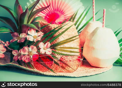Summer holiday accessories: straw hat, coconut drinks, sunglasses. palm leaves and exotic flowers , front view. Tropical and beach vacation concept