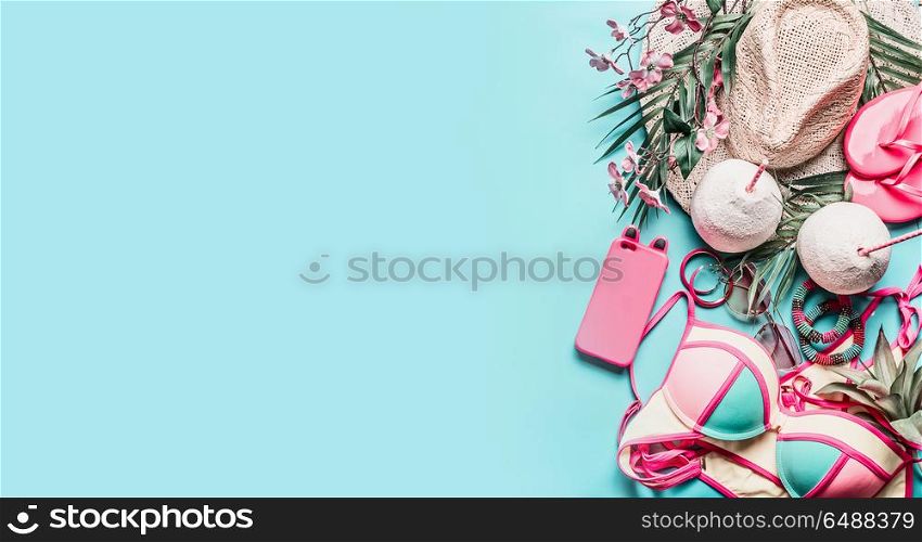 Summer holiday and travel accessories: straw hat, coconut drinks, bikini, and smart phone on turquoise blue background, top view, banner with place for text. Tropical and beach vacation concept