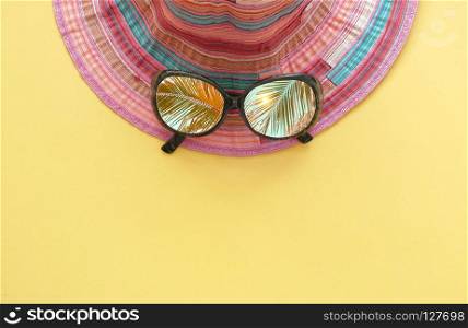 Summer holiday background, woman&rsquo;s hat sunglasses with palm tree reflection.
