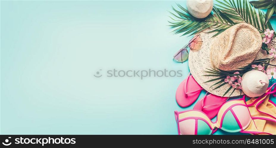 Summer holiday banner. Beach accessories : straw hat, palm leaves, sun glasses, pink flip flops , bikini and coconut cocktail on blue turquoise background, top view. Tropical vacation travel concept