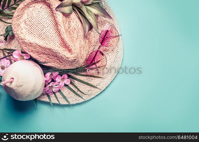 Summer holiday . Beach accessories : straw hat, palm leaves, pink sun glasses, flowers and coconut cocktail on blue turquoise background, top view. Tropical vacation travel concept