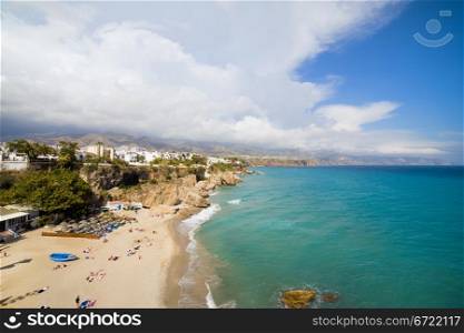 Summer holiday on Costa del Sol in Spain, sandy beach by the Mediterranean Sea in Nerja resort town.