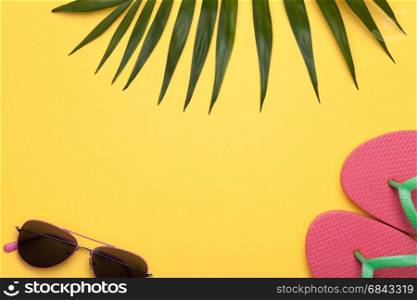 Summer holiday vacation background with beach accessories and green leaf of palm. Copy space. Top view