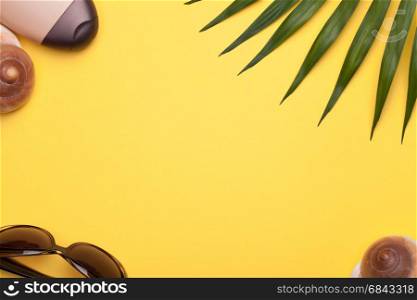 Summer holiday vacation background with beach accessories, shells and green leaf of palm. Copy space. Top view