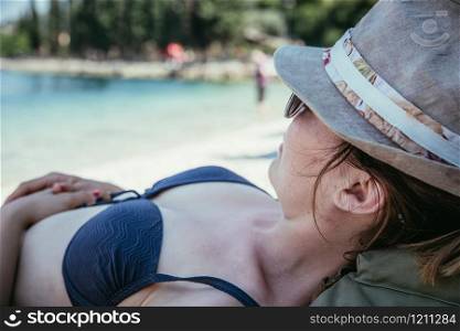 Summer holiday: young backpacking girl with straw hat in bikini enjoys the view. Italy