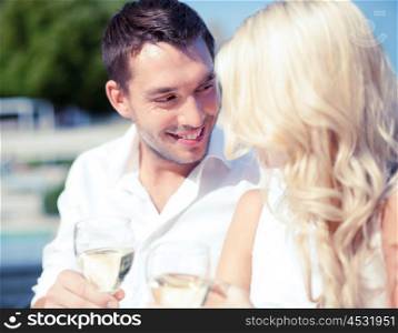 summer holidays and dating concept - couple drinking wine in cafe in the city. couple drinking wine in cafe