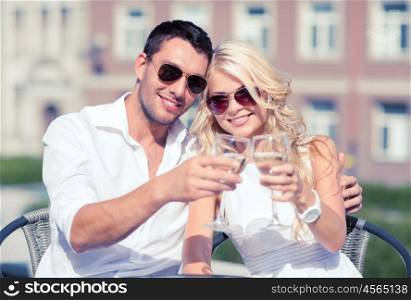 summer holidays and dating concept - couple drinking wine in cafe in the city. couple drinking wine in cafe