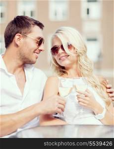 summer holidays and dating concept - couple drinking wine in cafe in the city