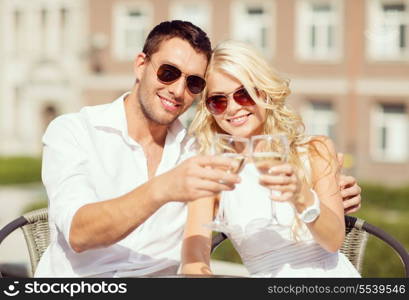 summer holidays and dating concept - couple drinking wine in cafe in the city