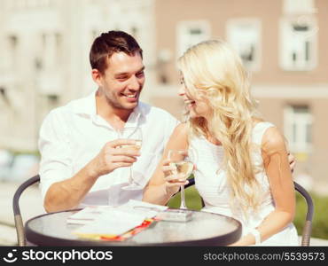 summer holidays and dating concept - couple drinking wine in cafe in the city