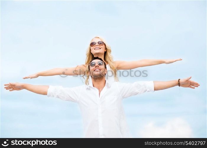 summer holidays and dating concept - couple holding hands up at sea side