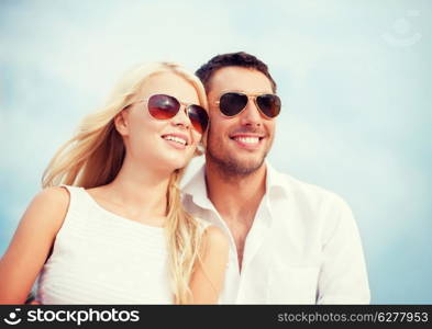 summer holidays and dating concept - couple in shades at sea side