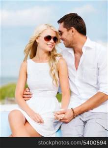 summer holidays and dating concept - couple in shades at seaside