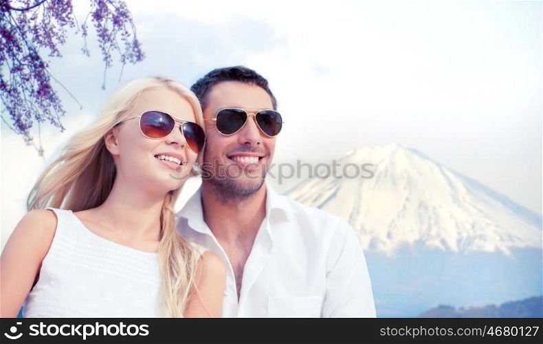 summer holidays and dating concept - couple in shades over fuji mountain background. happy couple over fuji mountain in japan