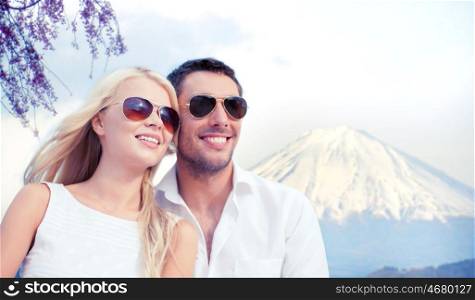 summer holidays and dating concept - couple in shades over fuji mountain background. happy couple over fuji mountain in japan