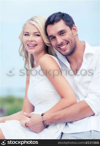 summer holidays and dating concept - couple in shades sitting at sea side. couple in shades at sea side