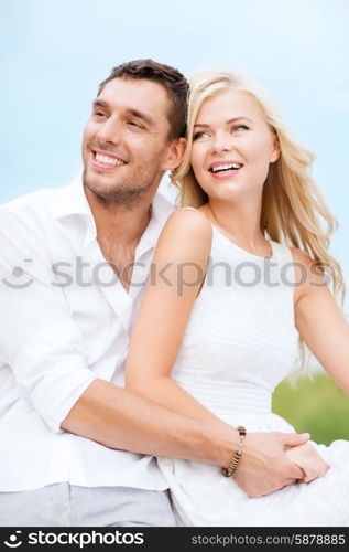 summer holidays and dating concept - couple in shades sitting at sea side