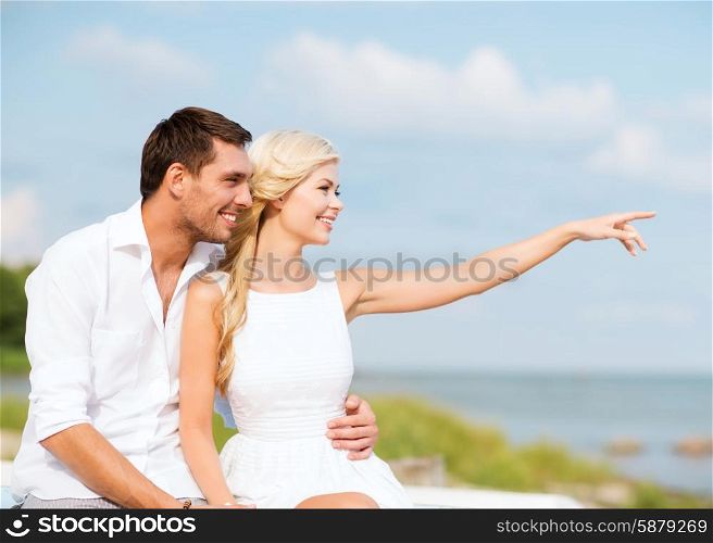 summer holidays and dating concept - couple sitting at sea side