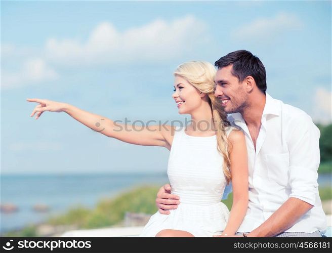 summer holidays and dating concept - couple sitting at sea side. couple sitting at sea side