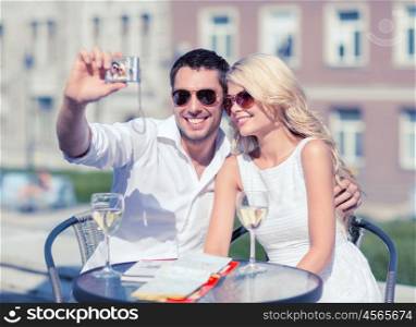 summer holidays and dating concept - couple taking photo in cafe in the city. couple taking photo in cafe