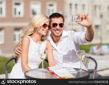 summer holidays and dating concept - couple taking photo in cafe in the city. couple taking photo in cafe
