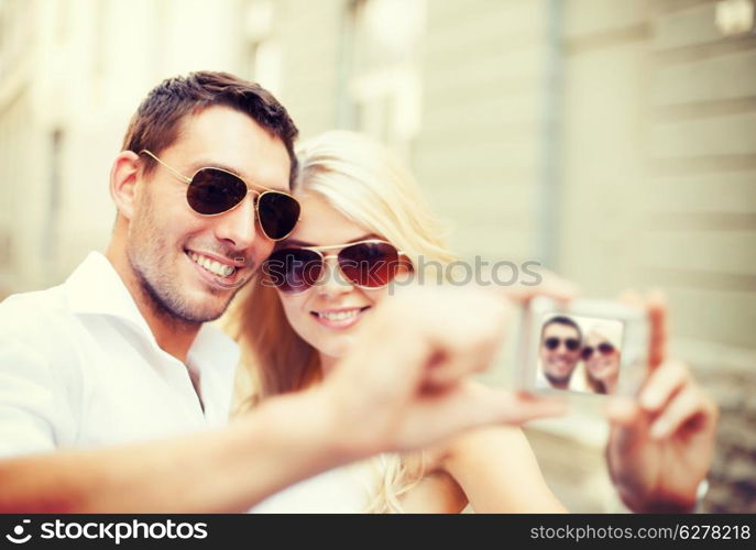 summer holidays and dating concept - couple taking photo in cafe in the city